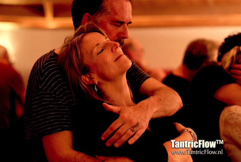 Een deelnemer houdt liefdevol een deelneemster in zijn armen tijdens een tantrische danssessie bij TantricFlow™.